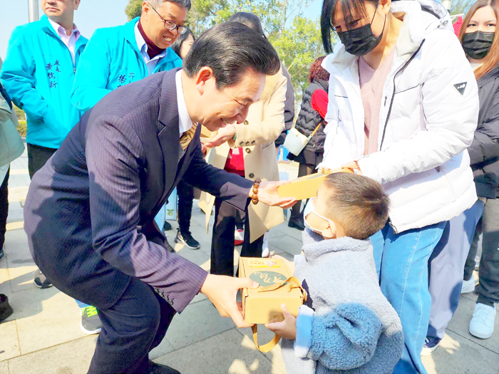 水試所春節活動,陳福海向民眾賀節,送福袋。(許峻魁攝)