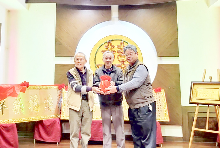 鎮南宮卸任主任委員許漢昌(左)與新任主委許明吉(右)進行交接儀式。(后沙許氏宗親會提供)