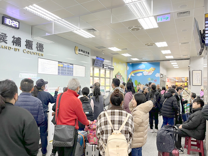 尚義機場受到濃霧影響,部分班機取消,候補櫃檯擠滿滯留旅客。(高凡淳攝)