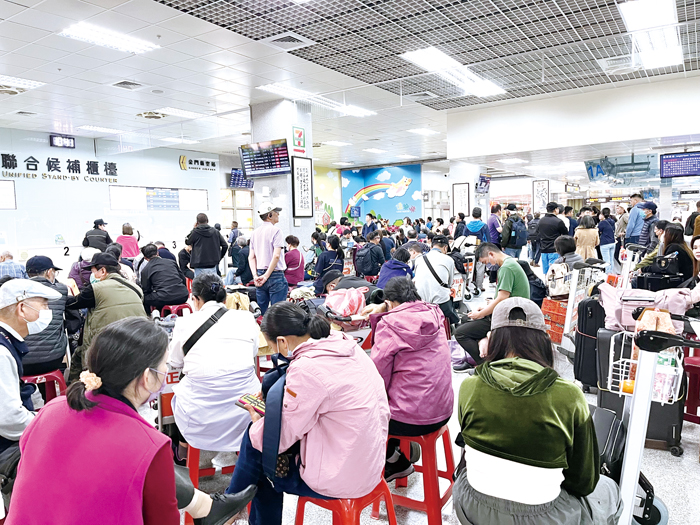 受到前天濃霧影響，大量滯留旅客昨日一早擠滿尚義機場候補櫃檯。（高凡淳攝）