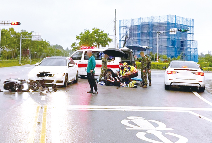 金湖鎮經武路交岔口發生交通事故，路過的三位軍人幫忙撐傘及照顧傷者。（湖警提供）