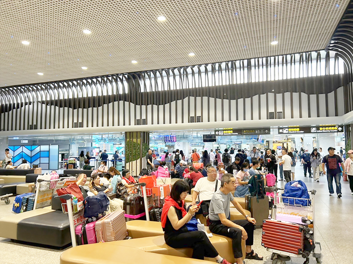 尚義機場因受天氣因素,一早取消飛往台中、台北的班機,機場擠滿滯留旅客。(高凡淳攝)