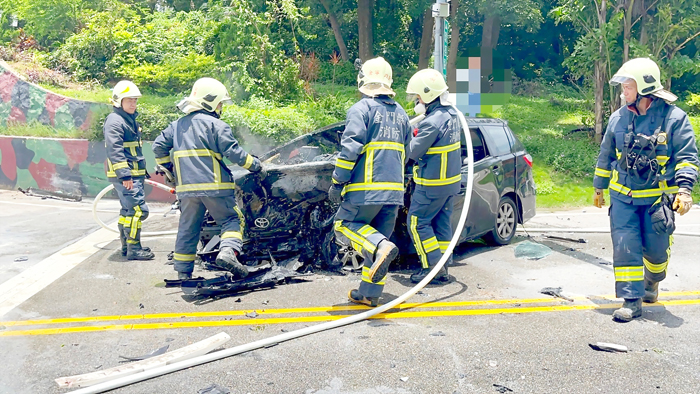圖為自小客車失控自撞小徑圓環擋土牆車頭起火，警消合作順利完成搶救任務。（消防局提供）