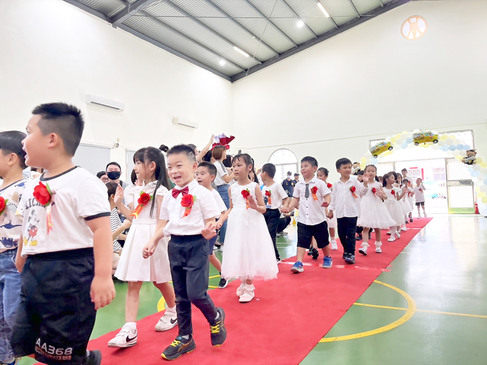 金鼎附幼舉行幼兒部第48屆畢業典禮,小小畢業生在師長的引領下,手牽手走進會場。(高凡淳攝)