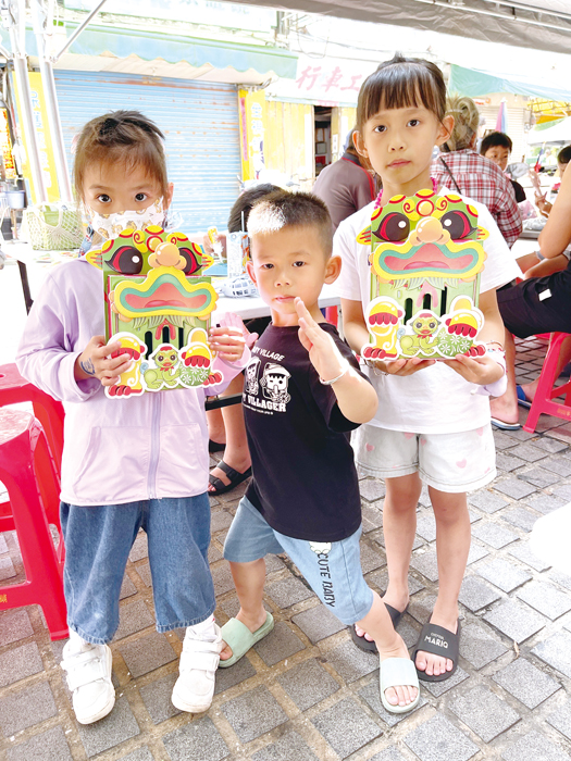 「風獅爺錢幣分類存錢筒」手作體驗,吸引大人小孩排隊索取。(陳麗妤攝)