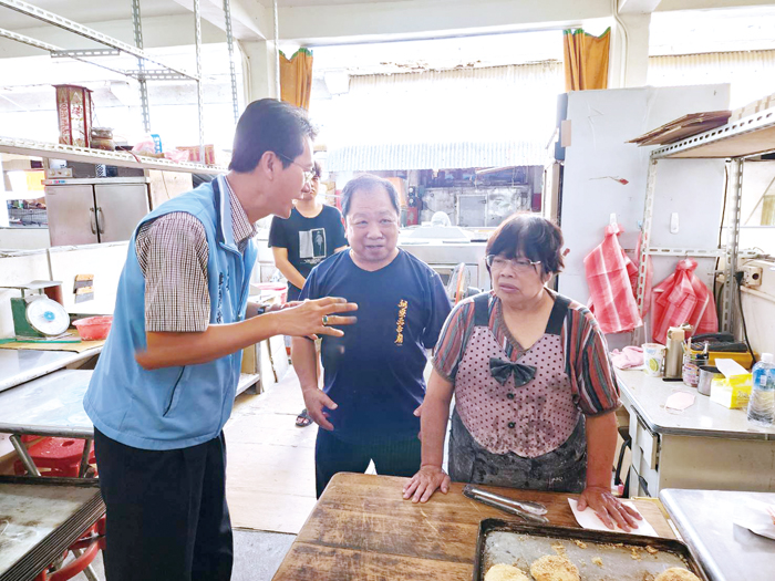 局長李廣榮(左)向攤商說明減塑政策。(許峻魁攝)