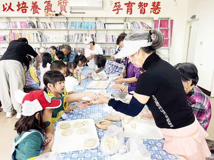 幼兒園學童聽阿嬤教導如何製作紅龜粿。(社會處提供)