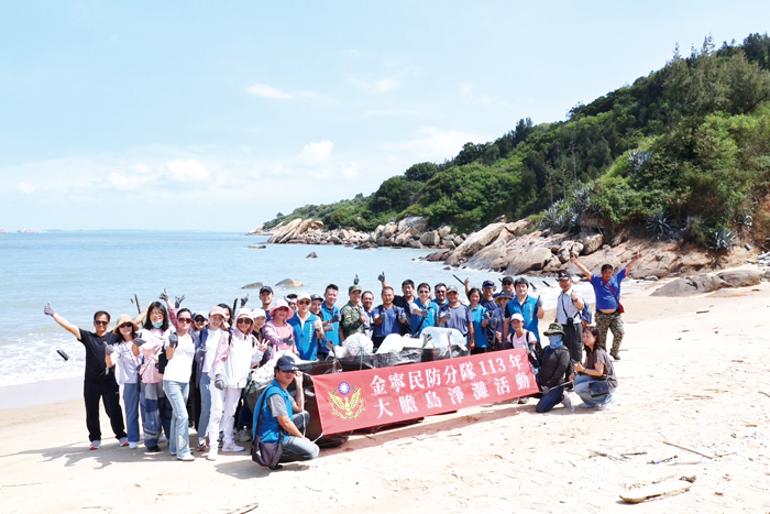 金寧民防分隊7日前往大膽島,舉辦環境教育與淨灘活動,並向駐軍致贈加菜金,表達慰問。(該分隊提供)