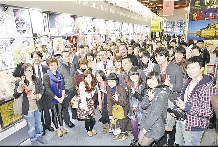 2012年三采文化首創三采插畫市集台北書展交流貿易平台,圖為插畫師與張輝明大合影(中間白色衣服)。(圖源:三采文化歷史照片)