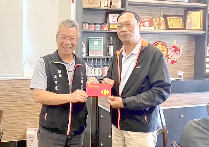 鎮長吳有家代表公所致贈禮券給每位里鄰長。(陳麗妤攝)