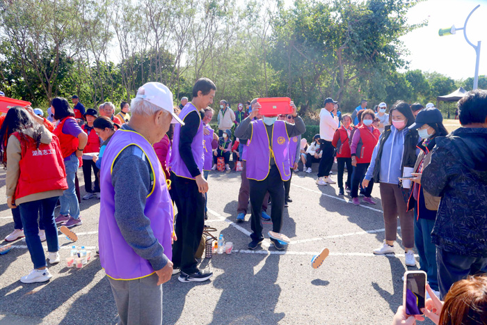鄉親在「福氣來擲杯」、「一公尺的愛」等兩項趣味活動比速度,現場充滿溫馨的快樂氣氛。(金寧鄉公所提供)
