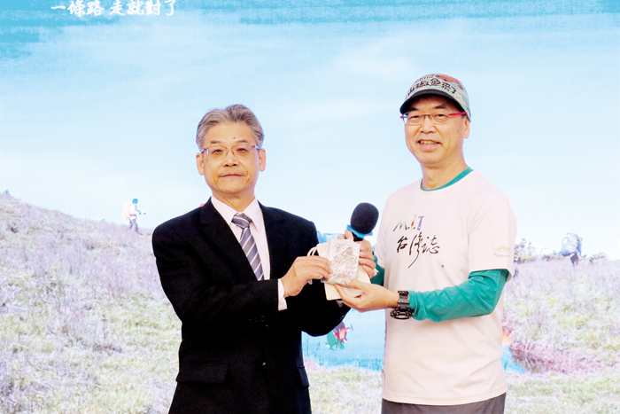 金門大學邀請知名紀錄片導演—麥覺明到校演講,分享山椒魚、臺灣山林:麥覺明(右)致贈大作《山椒魚來了》予金大。(金大提供)