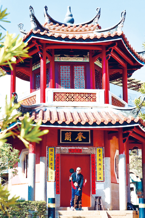 東門里里長周偉義帶著地區書法大師洪壽森親筆揮毫的春聯,前往奎閣貼上新春賀詞。(薛子軒攝)