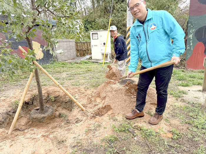 在眾人見證下,陳龍安董事長與李文良副縣長共同為營地大門口種下2公尺高的樟樹苗。(呂肇中攝)