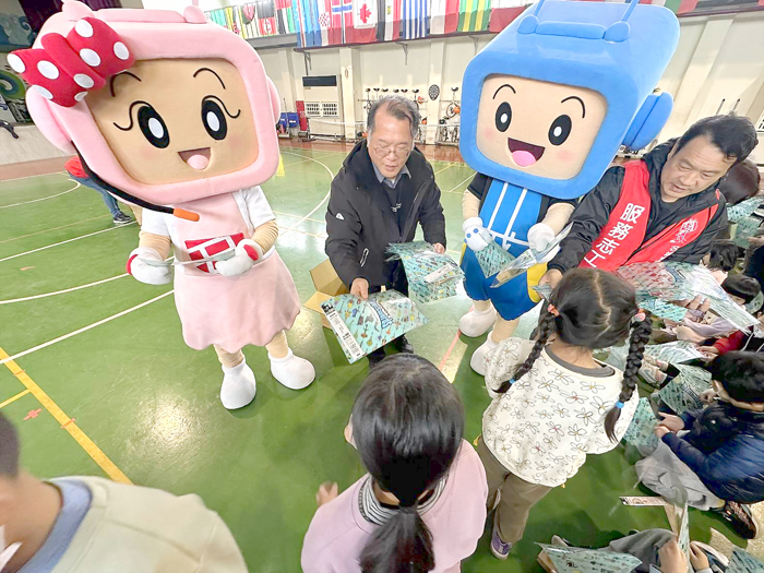 學生們領取兒童節小禮物,欣喜地與同學分享。(名城有線電視提供)