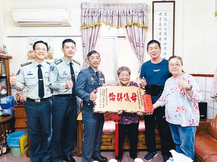 黃教昇上校頒贈賀屏予王英強委員之母王張金枝女士,表達敬意與祝賀。(後備服務中心提供)