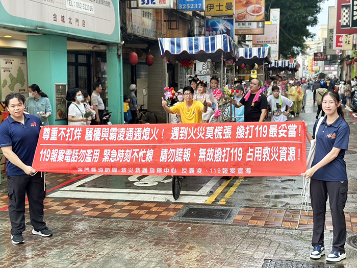 消防隊員許庭瑄與溫智鈞化身為「行動宣導員」,隨隊進行巡行。(消防局提供)