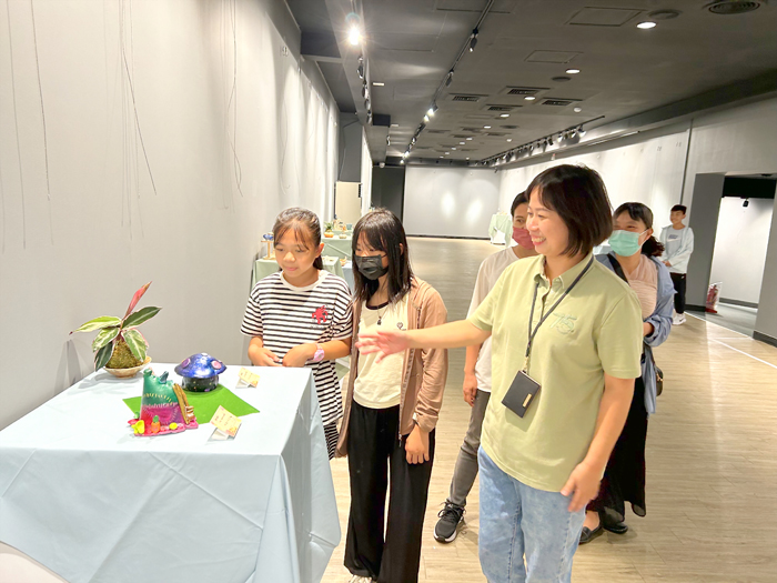 家扶中心主任洪依帆和參展者介紹作品特色。(許加泰攝)