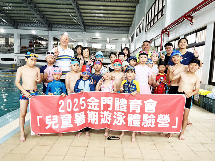 兒童暑期游泳體驗營在縣立游泳池登場,金門體育會唐麗輝副理事長與縣立體育場王志仁場長到場為學員們加油打氣並合照。(莊煥寧攝)