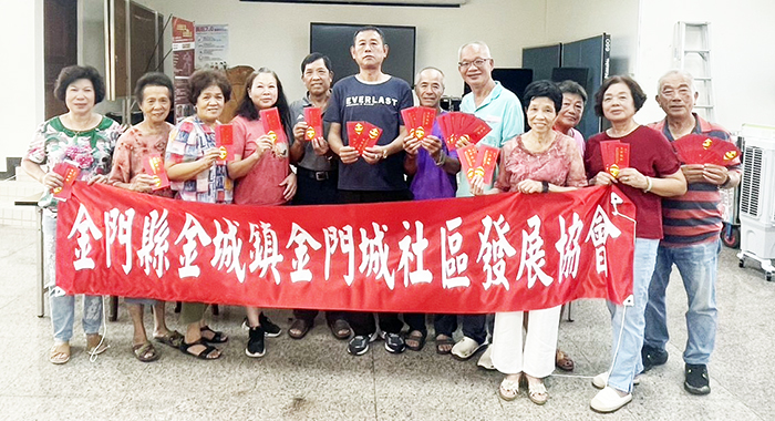 志工發禮券賀節,理事長陳介允(左五)、議員石永城(左六)、志工隊長李清聚(右1)及倪振瑞老師(右5)與志工們合影留念。(社區提供)
