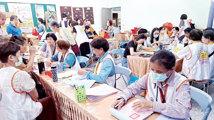 協助法會現場的插花協會義工、香積組義工及服務台的義工群默默奉獻照亮道場。(蔡麗玉攝)