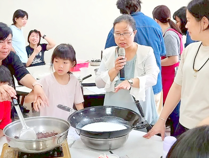 親子們在講師楊明幼的帶領下，完成桑椹奶酪。（農試所提供）