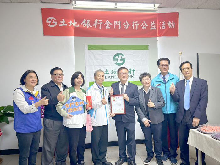 土地銀行金門分行舉行喬遷新址營運開業，來賓和接受公益捐贈的家扶中心代表合影。
（許加泰攝）