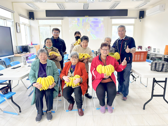 金沙鎮鎮長吳有家在社會課同仁陪同下，前往八個共餐服務據點，贈送長輩們香蕉作為長者餐後水果。（金沙鎮公所提供）