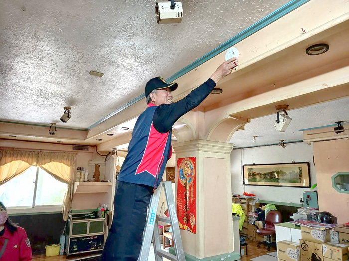 消防局結合精忠衛隊成員，協助安裝住宅用火災警報器。（消防局提供）