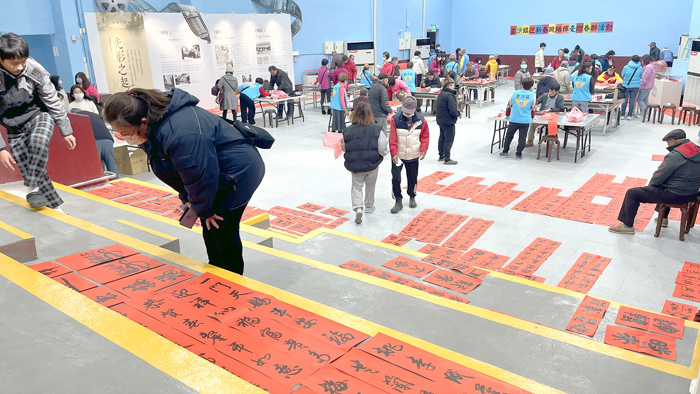 金沙鎮公所首次將「迎新春‧寫春聯」活動移師金沙戲院內辦理，民眾排隊領取春聯，展現出不同於以往的文化風景。（陳麗妤攝）