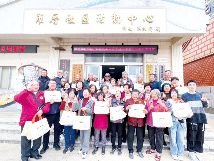 維菈公司總經理吳清安（前排左二）回饋鄉里，贈送長輩厚磅保暖衣、禦寒毛襪。（羅厝社區發展協會提供）