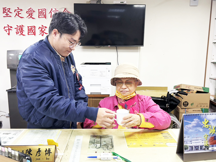 榮服處替代役同仁於寒冬中為年長榮民奉上熱茶，展現貼心關懷。
（榮服處提供）
