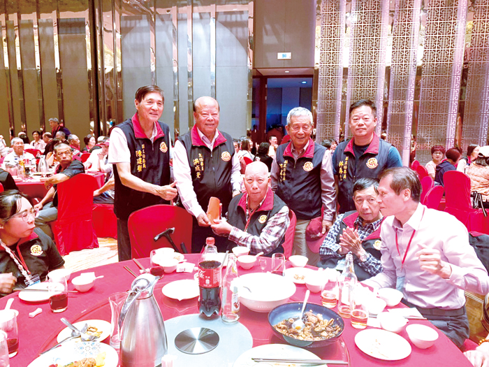 洪成發（左二）於平安宴贈送紅包予長者。（保生大帝廟管委會提供）