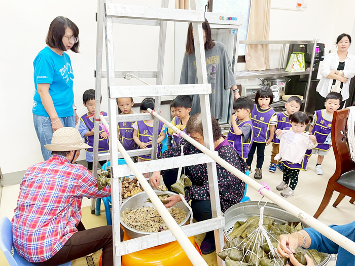 述美附幼學童參觀愛心志工們包粽過程。（述美國小提供）