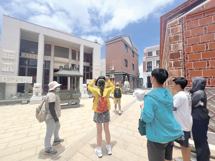 民眾於三忠廟聆聽導覽解說，認識地方信仰文化。（林秉志攝）