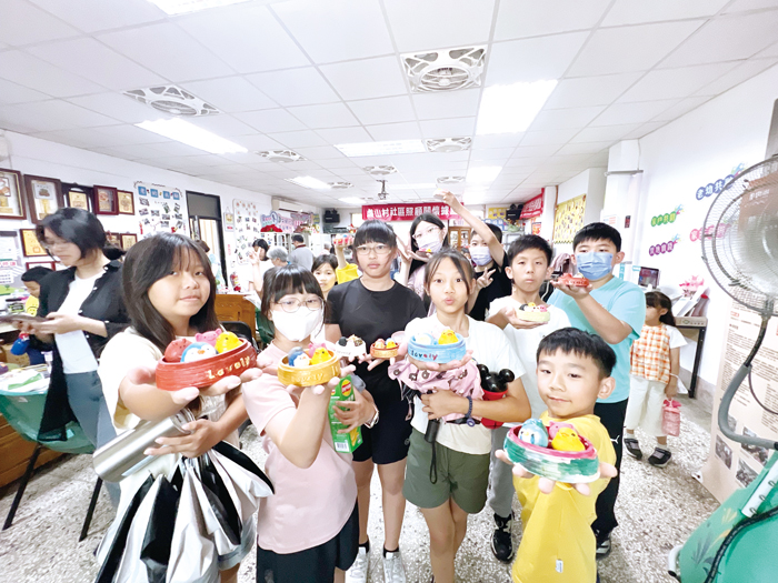 孩子們展示手作小蒸籠，臉上洋溢完成作品的喜悅。（林秉志攝）