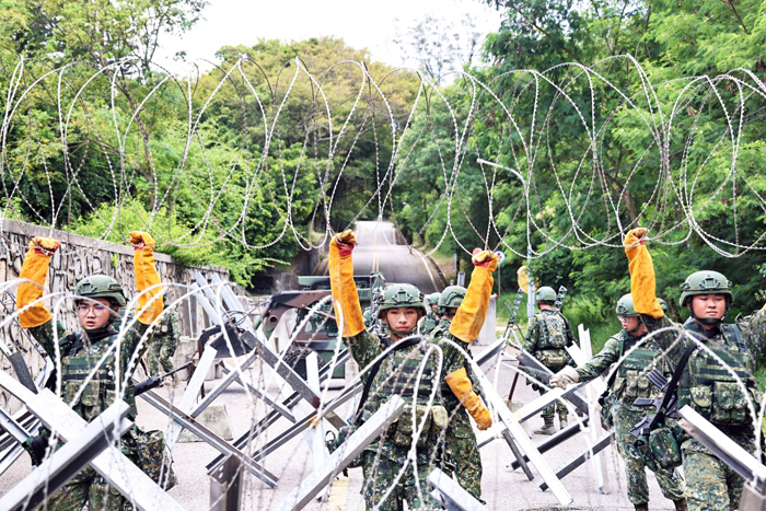 官兵結合地形地物，架設蛇腹型鐵絲網、鋼刺蝟、消波塊等阻材。
（金防部提供）