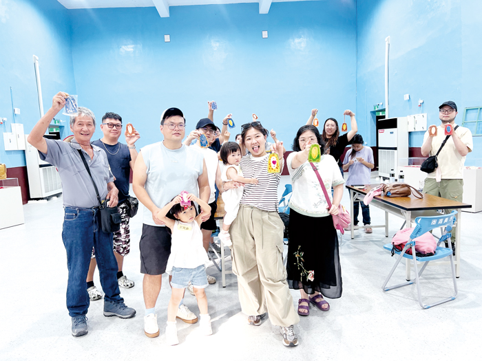 在金沙戲院體驗皮雕DIY後，開心展示手中完成的作品。（林秉志攝）