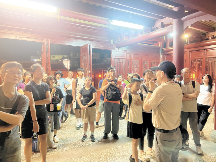 解說員在總兵署內向遊客們解說清代金門鎮總兵署的歷史與建築格局。（林秉志攝）