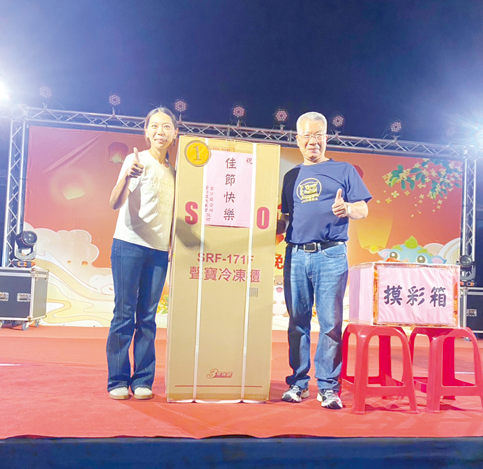 摸彩活動第一獎得主開心與吳有家鎮長合照。（李薇薇攝）