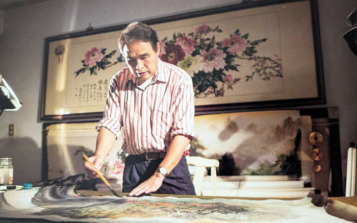 陳海贊揮著手中的筆，描繪著他眼中的金門。（陳海贊提供）