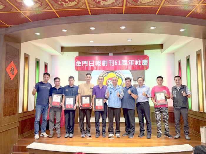 金門日報社資深員工上台接受表揚，現場與貴賓合照紀念。（李薇薇攝）