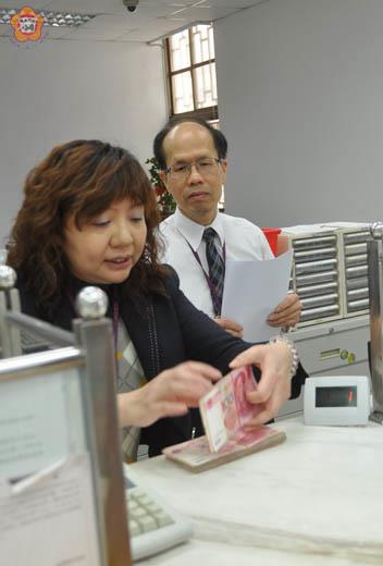   臺灣銀行人民幣業務已於昨天啟動；金門分行李文英（右）表示，透過兌換，以新台幣存成人民幣者，每人每天以二萬元人民幣為限。（張建騰攝）