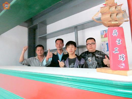   莊世明（左二）、莊陶結（左一）、方致中（右一）、呂昌豪（右二）等人在再生工坊的工作室有一個吧台，也是資源再利用的成品。（張建騰攝）