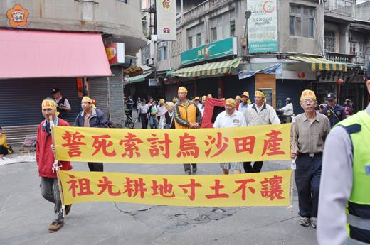 古寧頭南山烏沙土地原權人聯盟鄉親,昨日頭綁黃布條,抬著祖靈走上街頭,發出誓死索討烏沙田產,祖先耕地寸土不讓的訴求心聲。(李增汪攝)