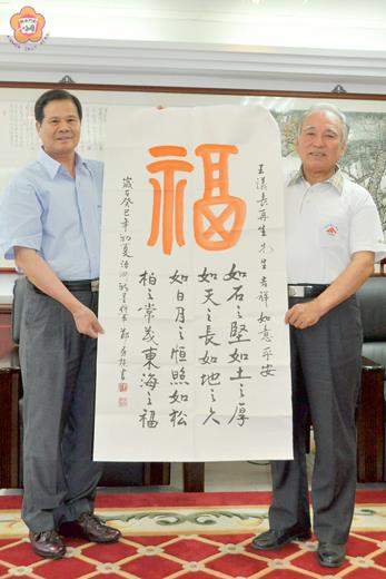   金門榮服處處長鄭有諒（左）將榮調台北市榮服處處長，昨前往議會辭行，同時以書法作品相贈，祝議長王再生（右）吉祥如意平安。（莊煥寧攝）