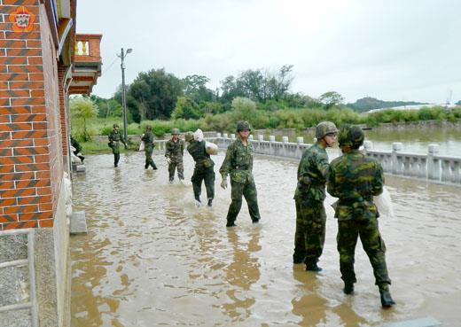 混砲營弟兄在後豐港協助淹水民宅實施沙包堆置，降低損失。（金防部提供）