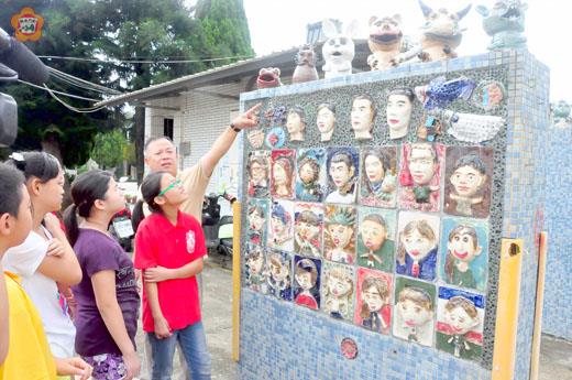   垵湖分校陶板作品，設置於校門口，師生一同欣賞。（許峻魁攝）