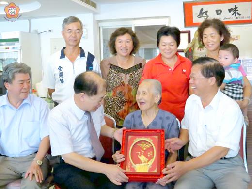 總統馬英九贈給一百零一歲人瑞呂陳甜的「松齡鶴壽」金箔畫昨天由李沃士送達,並與子、媳等人合影。
(張建騰攝)