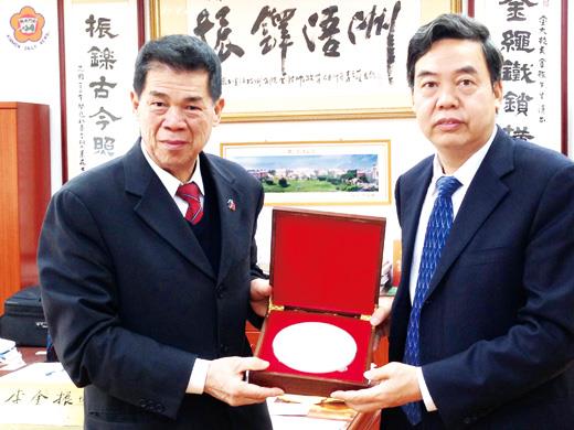   長安大學副校長趙均海（右）率該校相關部門主管抵金門大學參訪，雙方互贈紀念品。其中長安大學致贈的是藍田玉雕製而成的該校校徽。（許加泰攝）